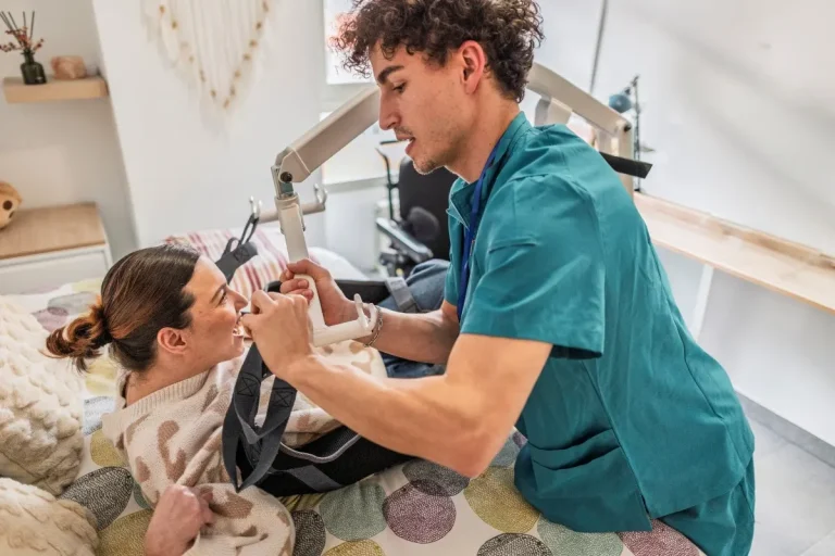 Nurse helping disabled woman in hoist